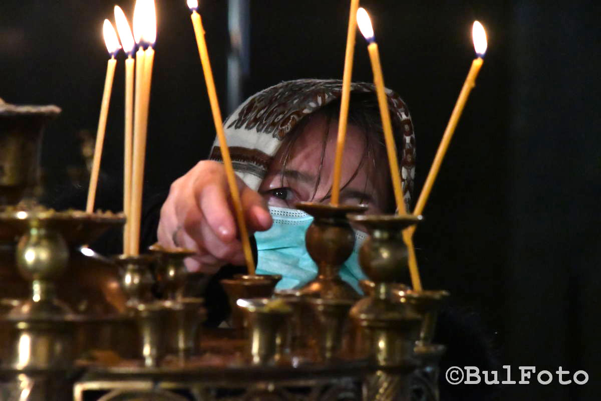 12 април 2020, вярваща пали свещ на Цветница в периода на големия Ковид локдаун, когато беше спорно дали е добре да се ходи на църква | Фотограф: Евгени Димитров