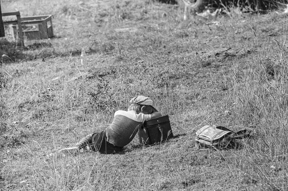 Виктор Герасимов силно изморен, спейки на фотографската си чанта, захвърлил настрани ученическата. По време на симките на бъги съзтезание кадри, част от които са били в първата фотоизложба с негово участие.